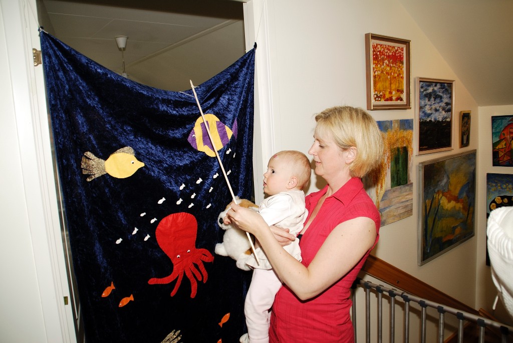 _DSC0077_1000074.JPG - Vi hade gamensamt 1:års kalas i mammagruppen hemma hos Karin, här fiskar Agnes bakom draperiet som Karin sytt själv.